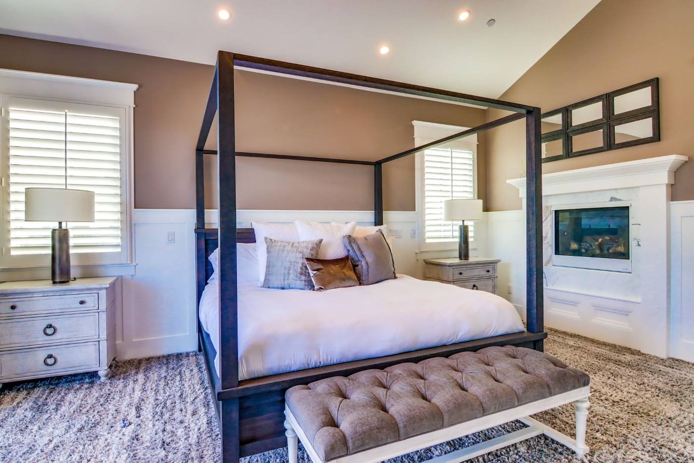 Primary bedroom with canopy bed and fireplace