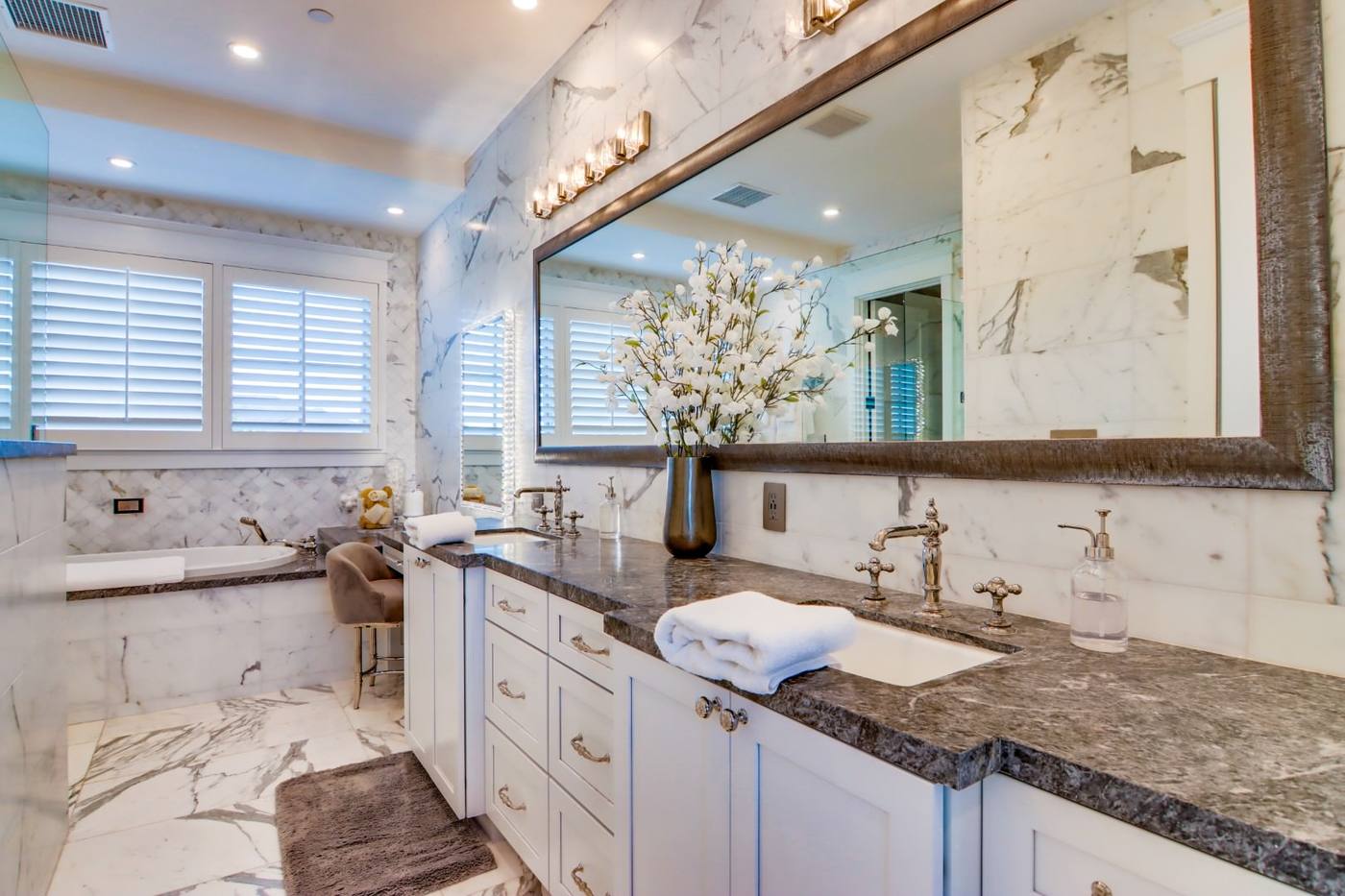 Primary bathroom with marble counters and dual vanity