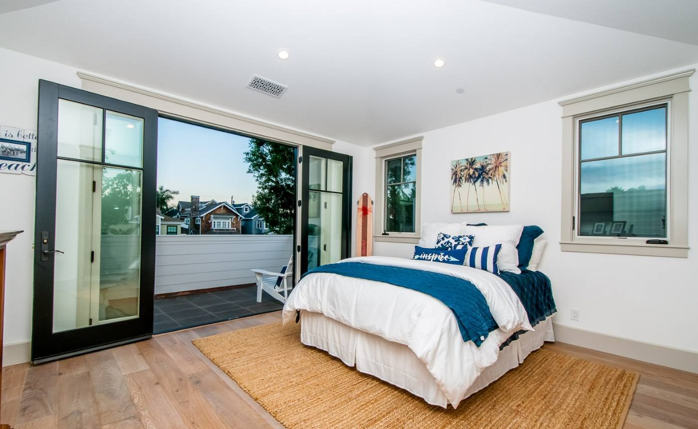 Primary bedroom with doors open to a private deck
