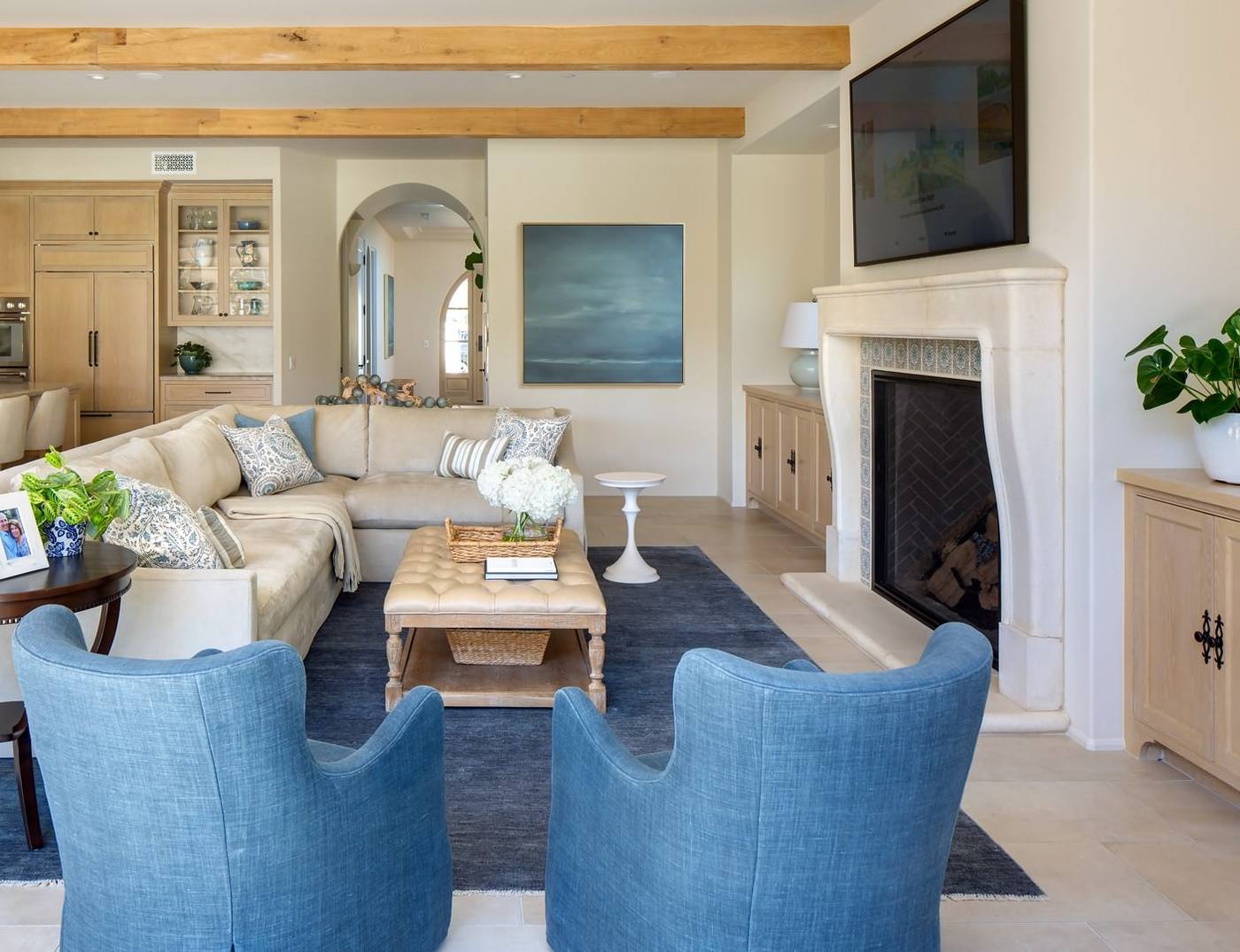 Living room with beamed ceiling and cast stone fireplace