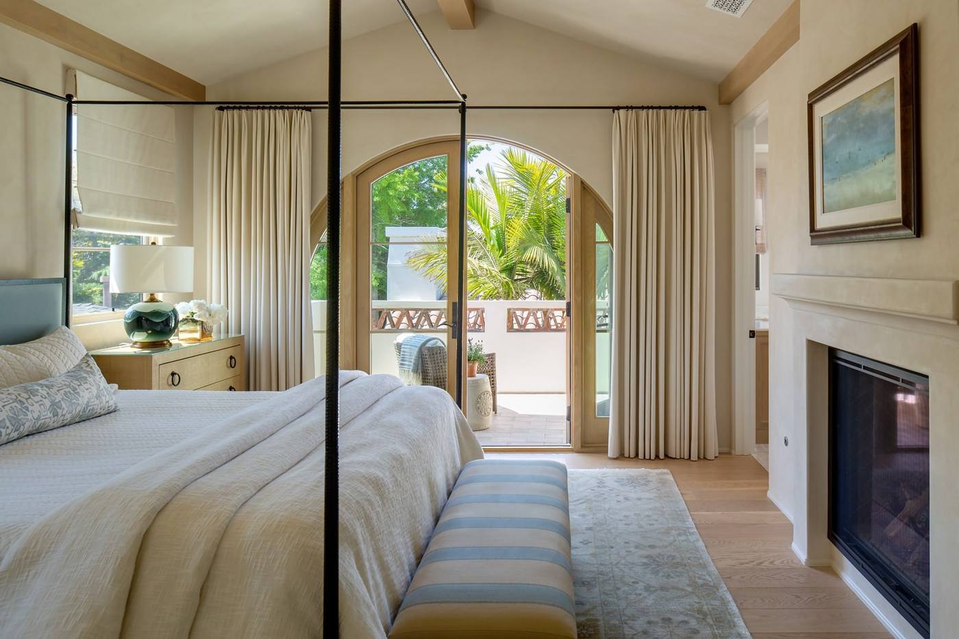 Primary bedroom with arched doors to a balcony