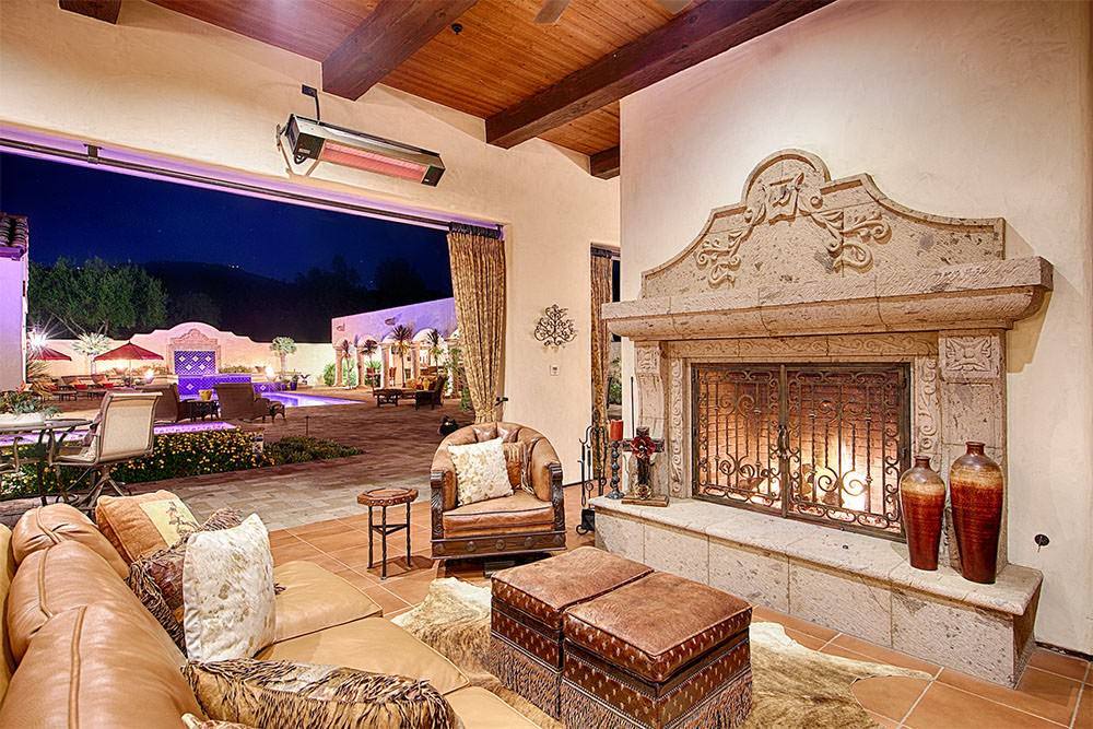 Covered outdoor living area with carved stone fireplace