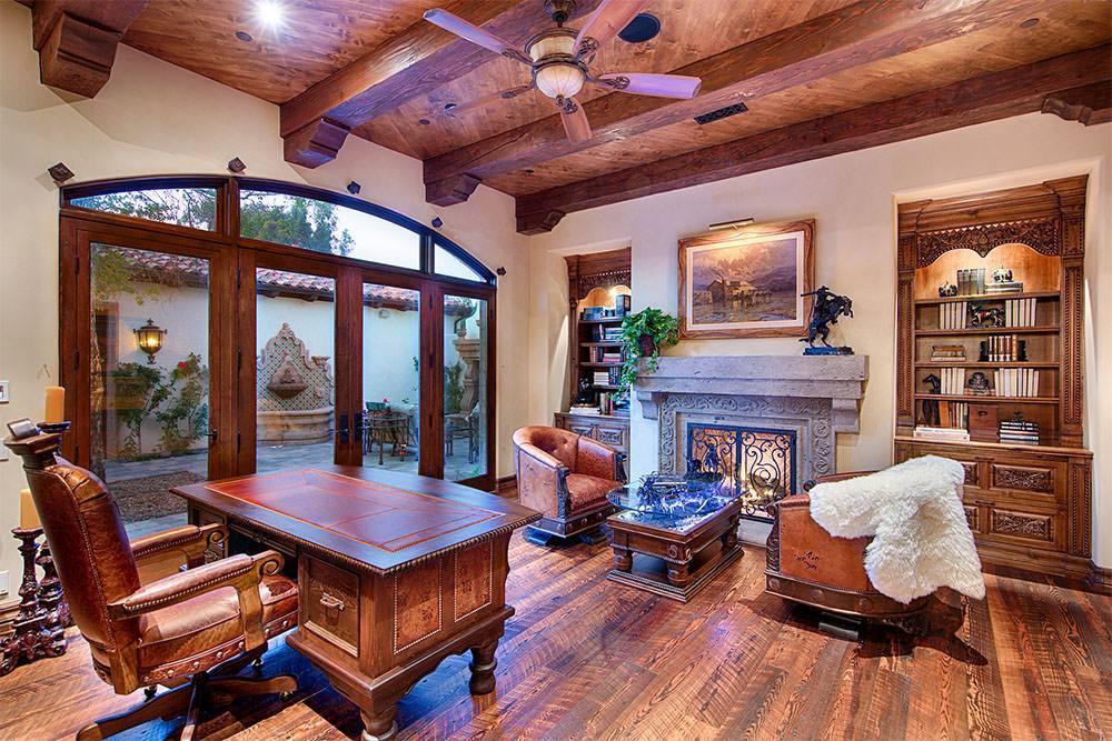 Study with carved millwork and stone fireplace